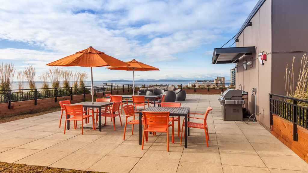 Orange outdoor restaurant furniture and overhead umbrellas.