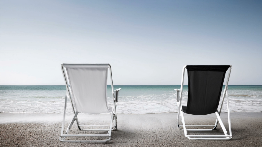 Black and white sling chairs sitting on the beach