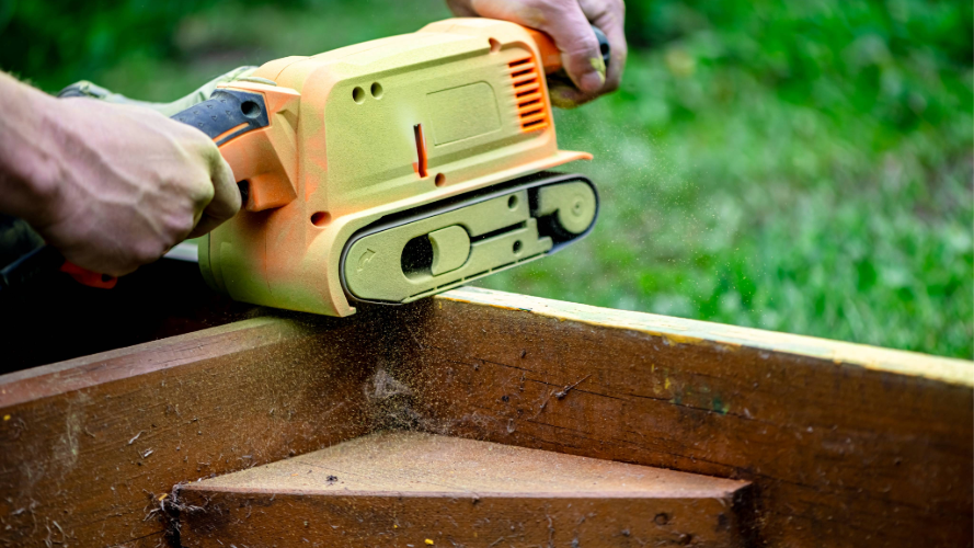 person sanding a wooden corner
