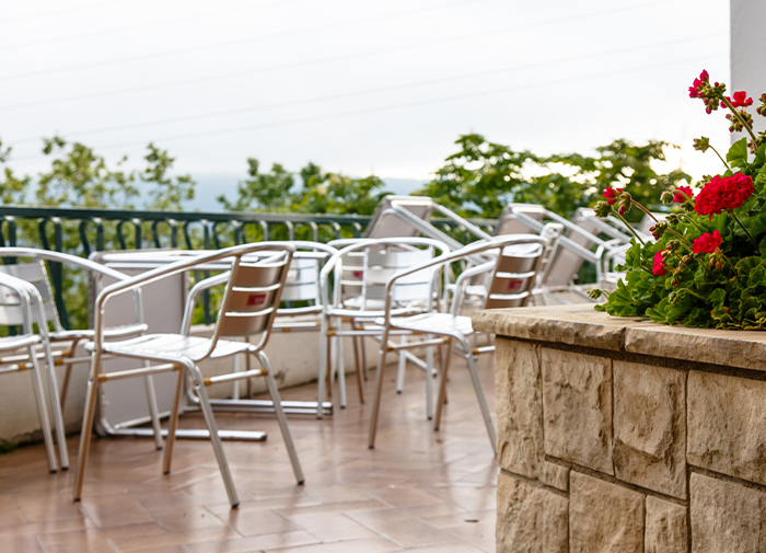 Outdoor Cafe Terrace Metal Chairs Red Flowers Scenic View
