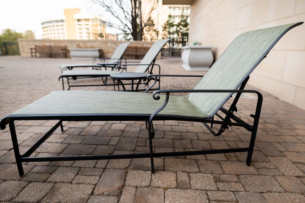 Restored outdoor patio chairs with newly installed mesh sling fabric on a backyard patio in Tonganoxie, KS