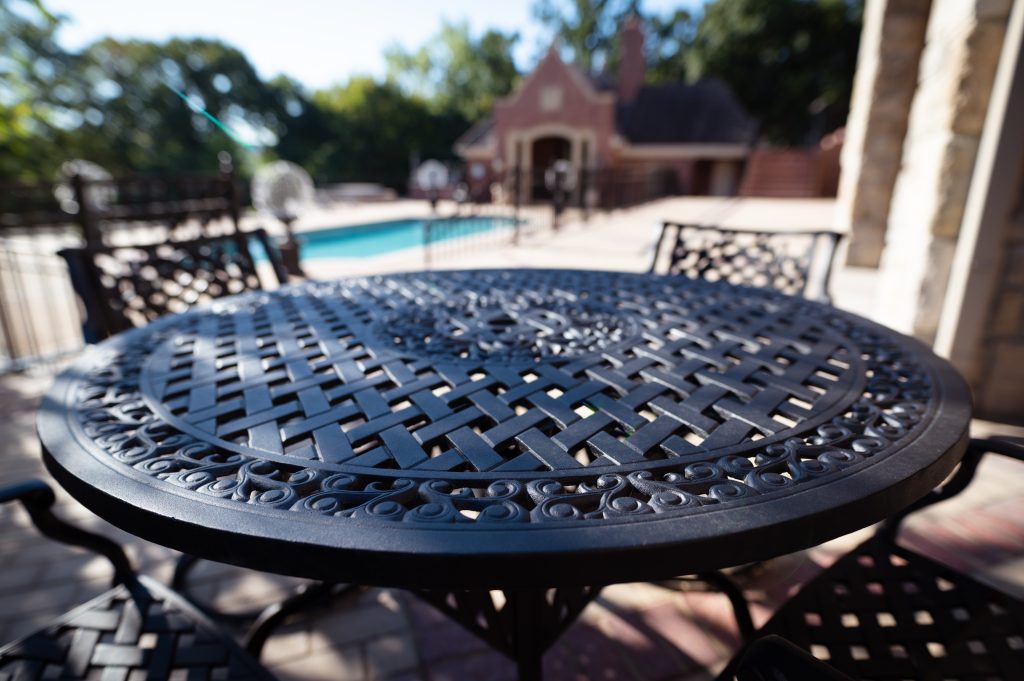Black wrought iron patio table with lattice top on a poolside patio in Kansas City
